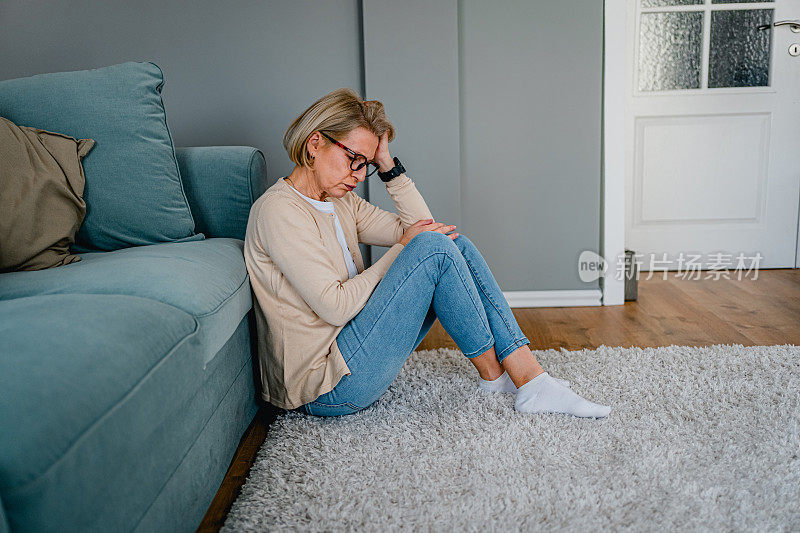 Depressed woman sitting alone on the floor